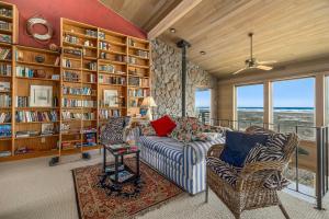 ein Wohnzimmer mit einer Couch und einem Bücherregal in der Unterkunft Fantastic Beach View! Oregon Escape with Game Room in Seaside
