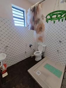 a tiled bathroom with a toilet and a window at A Oasis Taveta in Taveta +11 photos
