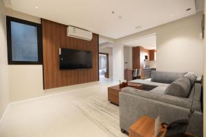 a living room with a couch and a flat screen tv at فندق رويال اديشن للشقق الفندقية in Buraydah