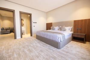 a bedroom with a large bed and a living room at فندق رويال اديشن للشقق الفندقية in Buraydah +25 photos