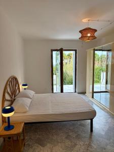a bedroom with a large bed and a large window at Elba Essence Suites in Portoferraio