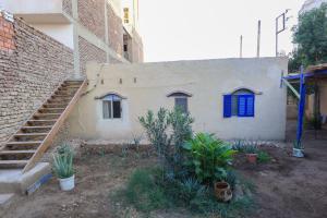 a small house with a blue window and stairs at Deja house in Luxor