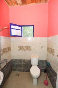 a bathroom with a toilet and a sink and a window at Deja house in Luxor