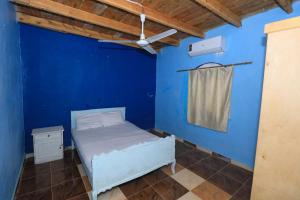 a blue room with a bed and a ceiling fan at Deja house in Luxor