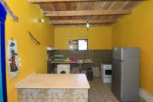 a kitchen with yellow walls and a refrigerator at Deja house in Luxor