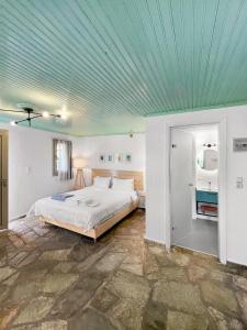 a bedroom with a bed and a blue ceiling at Panormos Beach Hotel Skopelos in Panormos Skopelos +85 photos