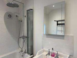een badkamer met douche, wastafel en spiegel bij Half Pint Cottage in Uplyme +56 foto's