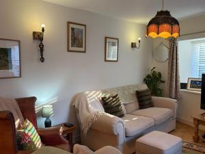a living room with a couch and a chair at Half Pint Cottage in Uplyme +56 photos