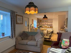a living room with a couch and a kitchen at Half Pint Cottage in Uplyme