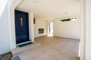 a hallway with a blue door and a tile floor at Casa com Vista para a Praia e Área Gourmet in São Sebastião +47 photos