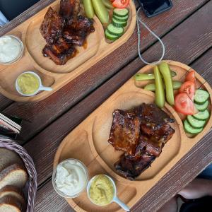 two wooden plates of food with meat and vegetables at Chata Hadimrška in Bartošovice v Orlických Horách