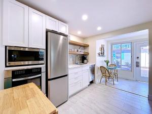 a kitchen with white cabinets and a stainless steel refrigerator at Paradise Cove at Island Getaway in Bradenton Beach