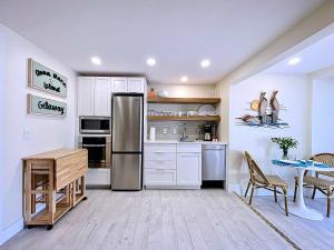 a kitchen with white cabinets and a stainless steel refrigerator at Paradise Cove at Island Getaway in Bradenton Beach
