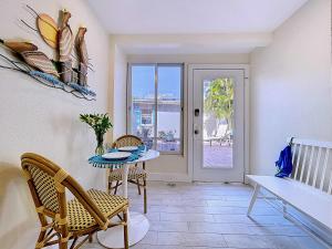 a dining room with a table and chairs and a door at Paradise Cove at Island Getaway in Bradenton Beach