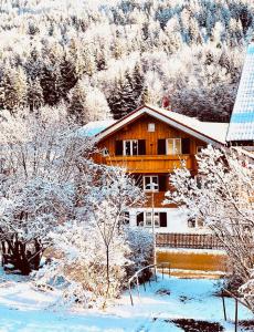 Wohlfühl Oase Loftwohnung Rottach ab 3 Nächten في ريتينبيرغ: منزل خشبي في الثلج اشجار مغطاة بالثلوج +18 صورة