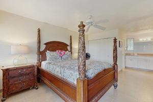 a bedroom with a wooden bed and a dresser at SandPiper #116a in Princeville