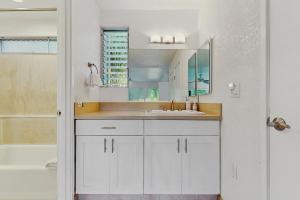a white bathroom with a sink and a tub at SandPiper #116a in Princeville +19 photos