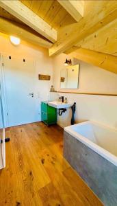 Wohlfühl Oase Loftwohnung Rottach ab 3 Nächten في ريتينبيرغ: حمام مع حوض استحمام ومغسلة