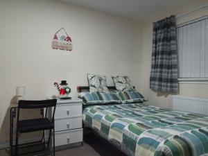 Un dormitorio con una cama, una silla y un escritorio. en Studio Twenty One, en Whitburn