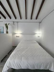 een slaapkamer met een wit bed en 2 verlichting bij Beachside Studio in Peaceful Almayate in Almayate Bajo