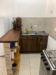 a kitchen with a counter and a sink and a stove at Casa a 100 metros da praia do Jabaquara in Paraty