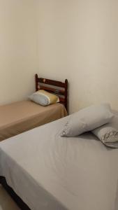two beds sitting next to each other in a room at Casa a 100 metros da praia do Jabaquara in Paraty