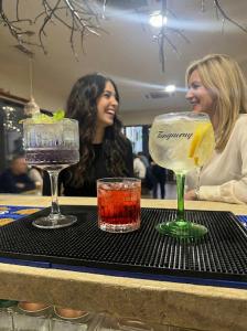 Dos mujeres sentadas en una mesa con dos cócteles. en Uni88 Apart Hotel, en Bucarest 257 fotos más