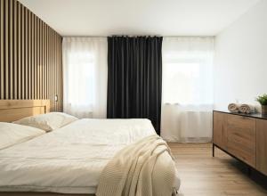 a bedroom with a large white bed and a window at Javorná - Aura a Nord in Čachrov