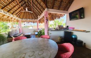 a dining room with a table and red chairs at Casa Rosa Paradise in Puerto Escondido