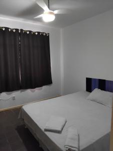 サルバドールにあるPPousada 03 min da praia, Itapuaのベッドルーム1室(黒いカーテン付きのベッド1台付)