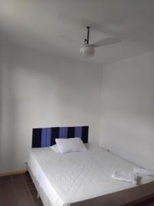 サルバドールにあるPPousada 03 min da praia, Itapuaの白い壁のドミトリールームのベッド1台分です。