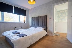 Spa & Rose Cottages Gilsland في Gilsland: غرفة نوم بسرير كبير ونافذة