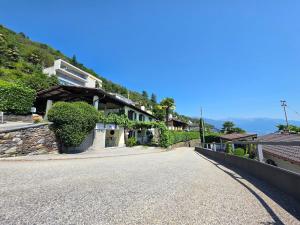 a road with a house on the side of a hill at Casa Leyian - Free parking in Brissago