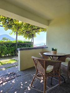 a table and chairs on a patio with a view of the ocean at Casa Leyian - Free parking in Brissago