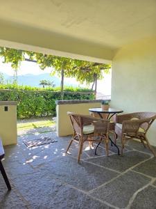 a patio with a table and chairs on a patio at Casa Leyian - Free parking in Brissago +31 photos