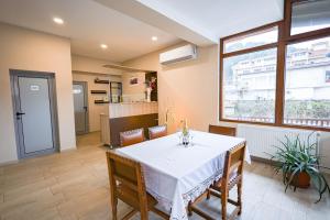a dining room with a white table and chairs at Family Hotel Alex in Zlatograd