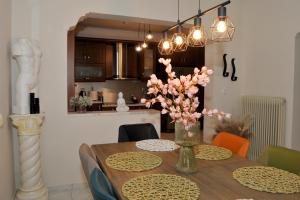 a dining room table with a vase of flowers on it at Anastasia Meteora Residence in Kalabaka