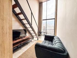 a living room with a couch and a large window at Flat 119 in Bogotá