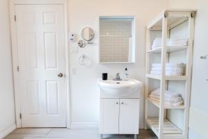 a white bathroom with a sink and a mirror at AFRICA - SelfCheckIn - Plateau - St-Laurent in Montréal +31 photos