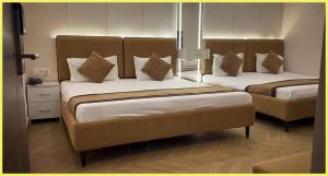 Un dormitorio con dos camas con almohadas sobre ellas. en SEA VIEW from rooftop HOTE S NIWAS ! PURI near Swargadwar - Golden Beach - Jagannath Temple - Parking - Fully Air Conditioning Rooms - BEST HOTEL IN PURI, en Puri