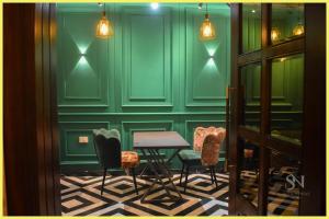 Una habitación verde con sillas, una mesa y luces. en SEA VIEW from rooftop HOTE S NIWAS ! PURI near Swargadwar - Golden Beach - Jagannath Temple - Parking - Fully Air Conditioning Rooms - BEST HOTEL IN PURI, en Puri