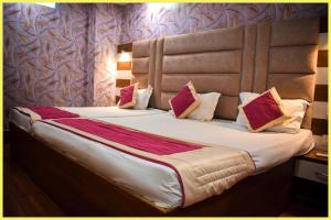 Un dormitorio con una cama grande con almohadas. en SEA VIEW from rooftop HOTE S NIWAS ! PURI near Swargadwar - Golden Beach - Jagannath Temple - Parking - Fully Air Conditioning Rooms - BEST HOTEL IN PURI, en Puri