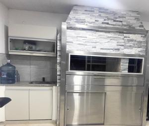 een keuken met een roestvrijstalen koelkast en een magnetron bij Casa moderna en barrio in Villa Ángela