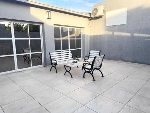 twee banken op een terras met ramen bij Casa moderna en barrio in Villa Ángela