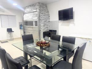 een eetkamer met een glazen tafel en stoelen bij Casa moderna en barrio in Villa Ángela