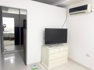 een woonkamer met een tv en een dressoir met een dressoir bij Casa moderna en barrio in Villa Ángela +7 foto's