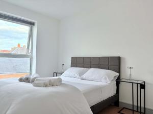 two white beds in a bedroom with a large window at Modern 2 Bed Apartment in York City Centre - Best York Location - Steps from Top Attractions in York