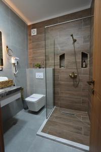 a bathroom with a shower with a toilet and a sink at Hotel Boutique Ergjeria in Gjirokastër +48 photos