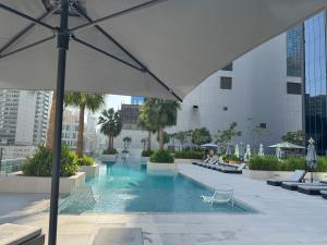 uma piscina num edifício com guarda-chuva em The Sterling 4 sleep with AC parking and pool em Sabkhah
