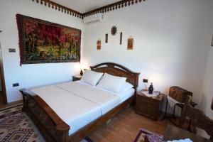 a bedroom with a bed and a painting on the wall at Hotel Boutique Ergjeria in Gjirokastër